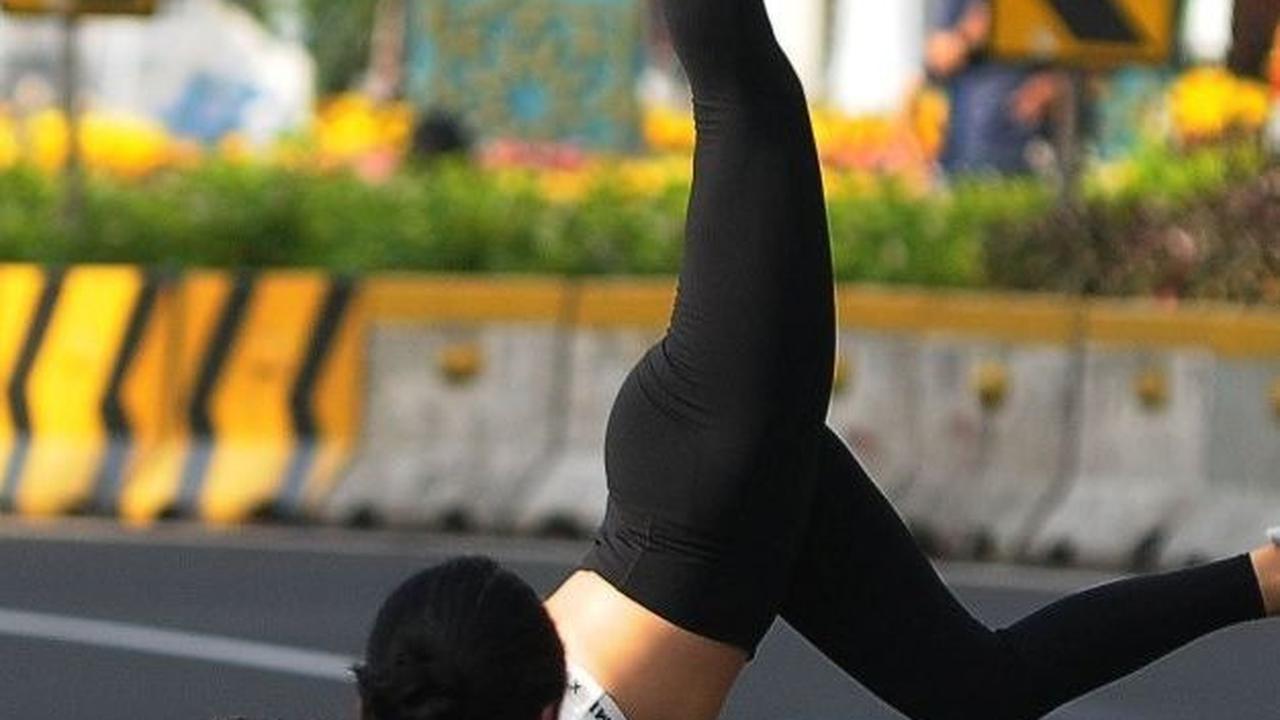 Warga mengabadikan momen seorang wanita saat melakukan foto atraktif di tengah jalan protokol Jakarta. Foto: merdeka.com / Imam Buhori