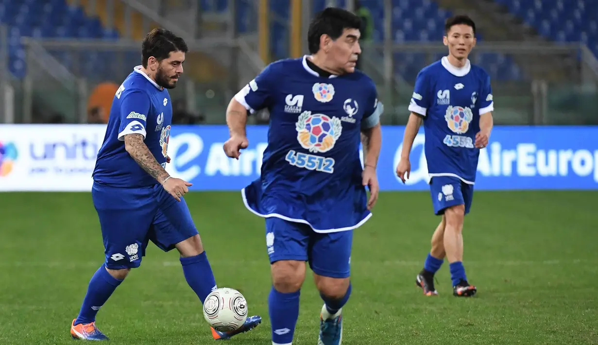 Diego Armando Maradona jr. (kiri) bermain bersama ayahnya, Diego Armando Maradona (tengah), pada laga amal bertajuk 'United for Peace', di Stadion Olimpico, Roma, Kamis (13/10/2016) dini hari WIB. (EPA/Alessandro Di Meo)