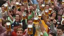 Para peserta mengangkat gelas bir saat pembukaan festival bir terbesar di dunia Oktoberfest ke-185 di Munich, Jerman, Sabtu (22/9). (Christof STACHE/AFP)