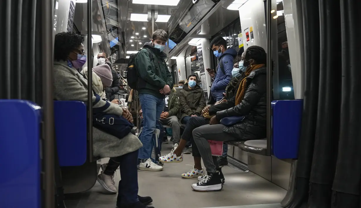 Orang-orang yang memakai masker untuk melindungi diri dari COVID-19 naik kereta bawah tanah di Paris (14/1/2022). Pencabutan larangan COVID terhadap turis Inggris menjadi dorongan besar bagi wisatawan dan pemain ski yang tiba di bandara dan stasiun kereta. (AP Photo/Michel Euler)