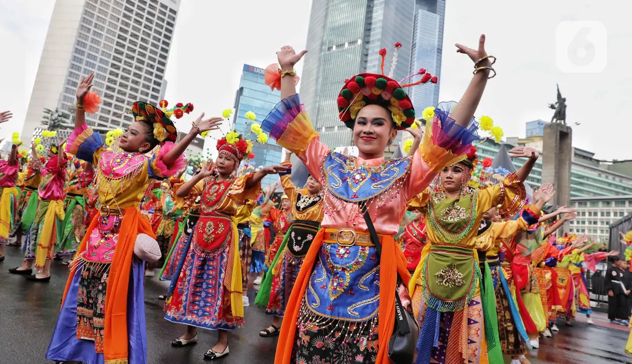 Sejumlah penari menampilkan tarian khas betawi saat pertunjukan kolosal budaya pada Hari Bebas Kendaraan Bermotor (HBKB) atau Car Free Day (CFD)di kawasan Bundaran Hotel Indonesia (HI), Jakarta, Minggu (6/7/2025). (Liputan6.com/Angga Yuniar)