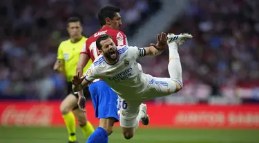 Bek Atletico Madrid Stefan Savic berebut bola dengan bek Real Madrid Nacho dalam laga pekan ke-35 Liga Spanyol di Wanda Metropolitano, Senin (9/5/2022) dini hari WIB. Atletico Madrid berhasil menang dengan skor tipis 1-0 atas Real Madrid. (AP Photo/Manu Fernandez)