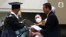 Ayah Brigadir Nofriansyah Yosua Hutabarat atau Brigadir J, Samuel Hutabarat (kanan) menerima ijazah dari Rektor Universitas Terbuka Ojat Darojat saat mewakili anaknya mengikuti prosesi wisuda di Universitas Terbuka, Pamulang, Tangerang Selatan, Banten, Selasa (23/8/2022). Brigadir J tercatat sebagai mahasiswa Program Studi Ilmu Hukum, Fakultas Hukum dan Ilmu Sosial dan Ilmu Politik di Unit Program Belajar Jarak Jauh Universitas Terbuka Jambi. (Liputan6.com/Herman Zakharia)