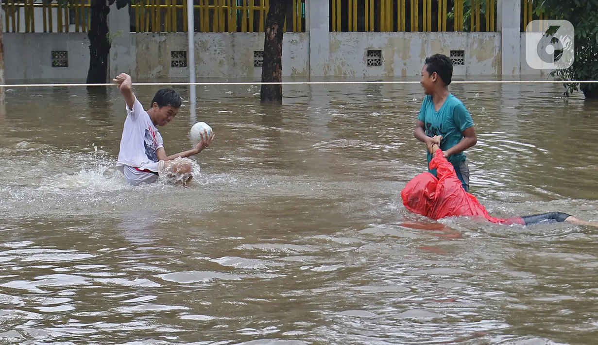 Warga terjatuh saat melintasi banjir yang merendam Jalan Pondok Raya Gede, Jakarta Timur, Selasa (25/2/2020).  Sejumlah ruas jalan tergenang dan akses ke beberapa wilayah terputus, salah satunya Jalan Pondok Raya Gede. (Liputan6.com/Herman Zakharia)