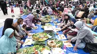 Ribuan masyarakat Garut, Jawa Barat nampak ceria menikmati sajian makan gratis festival 1.000 nasi liwet di Lapang Otista Alun-alun Garut. (Liputan6.com/Jayadi Supriadin)