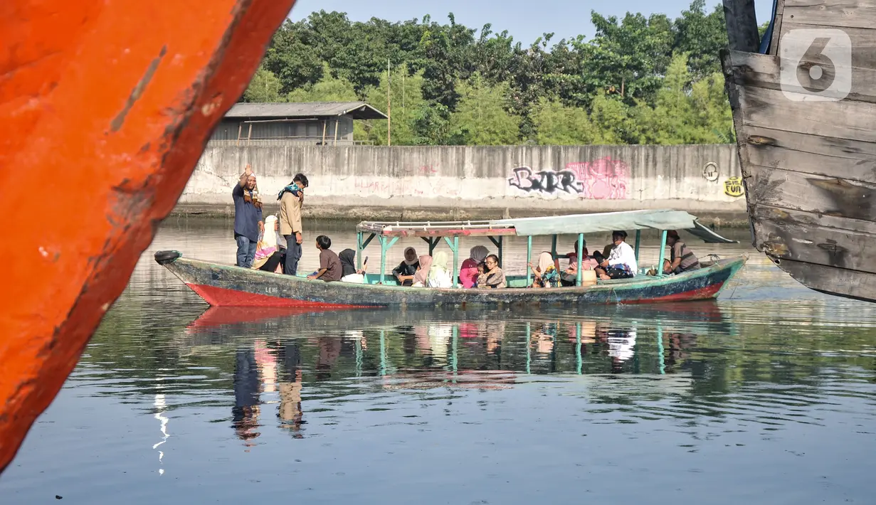 Warga menggunakan perahu sebagai transportasi menuju lokasi salat Idul Fitri 1444 H di Pelabuhan Sunda Kelapa, Jakarta, Sabtu (22/4/2023). (merdeka.com/Iqbal S. Nugroho)