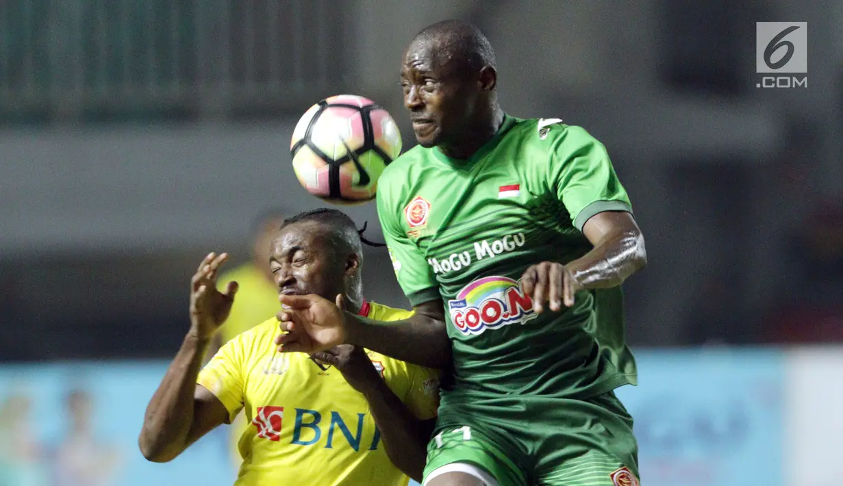 Pemain baru PS TNI, Franklin Anzite Touadere (kanan) berebut bola atas dengan pemain Bhayangkara FC, Guy Junior saat lanjutan Liga 1 Indonesia di Stadion Pakansari, Kab Bogor, Minggu (3/9). PS TNI kalah 0-1. (Liputan6.com/Helmi Fithriansyah)
