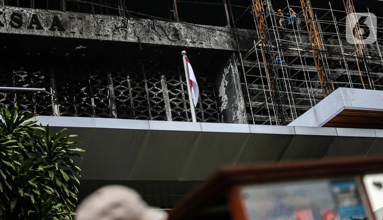 Pekerja memasang 'scaffolding' atau struktur besi untuk melakukan perbaikan Gedung Kejaksaan Agung, Jakarta, yang hangus terbakar, Rabu (7/10/2020).  Kebakaran pada 22 Agustus 2020 lalu mengakibatkan kerusakan berat pada seluruh bangunan Gedung Utama Kejaksaan Agung. (Liputan6.com/Faizal Fanani)