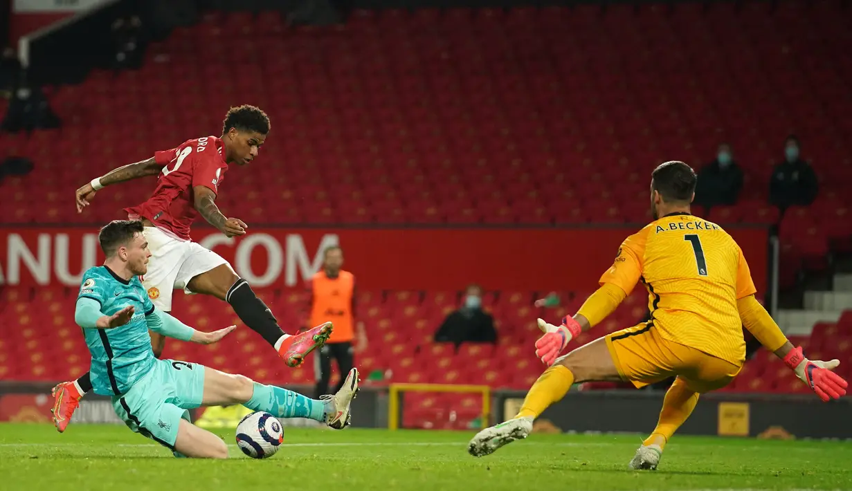 Striker Manchester United, Marcus Rashford (tengah) melepaskan tendangan yang berbuah gol kedua timnya ke gawang Liverpool dalam laga lanjutan Liga Inggris 2020/2021 pekan ke-35 di Old Trafford, Kamis (13/5/2021). Manchester United kalah 2-4 dari Liverpool. (AFP/Dave Thompson/Pool)