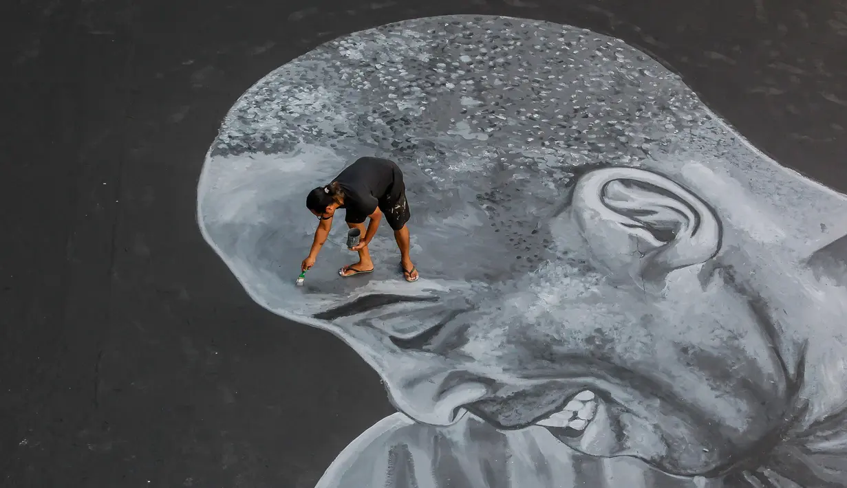 Seorang seniman melukis mural raksasa pada lantai sebuah lapangan basket untuk menghormati mantan bintang NBA Kobe Bryant dan putrinya Gianna di Taguig City, Filipina, Selasa (28/1/2020). Kobe Bryant dan Gianna meninggal dalam kecelakaan helikopter pada 26 Januari 2020. (Xinhua/Rouelle Umali)