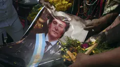 Para dukun memegang foto Presiden Argentina Javier Milei saat mereka melakukan ritual tahunan untuk memprediksi isu-isu politik dan sosial pada tahun baru, di puncak bukit San Cristobal di Lima, Peru, Rabu, 27 Desember 2023. (AP Photo/Guadalupe Pardo)