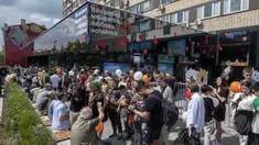 Warga berbaris untuk mengunjungi restoran cepat saji yang baru dibuka di bekas gerai McDonald's di Bolshaya Bronnaya Street, Moskow, Rusia, 12 Juni 2022. Papan itu bertuliskan 'Nama Berubah, Cinta Tetap'. (AP Photo/Dmitry Serebryakov)