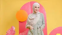 Hadir dengan nuansa pastel adalah pilihan yang tepat, lho. Kamu dapat mengenakan gamis berwarna sage green dengan detail list nude pada saku, belt dan kancing. (instagram/shireensungkar)