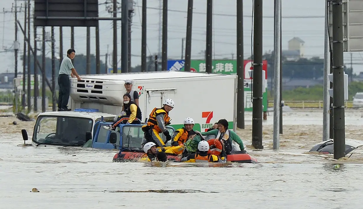 Petugas pemadam kebakaran mengevakuasi warga yang terjebak luapan banjir dari Sungai Kinugawa di Joso, prefektur Ibaraki, Jepang, Kamis (10/9). Satu orang hilang dan lebih dari 90 ribu warga diperintahkan untuk mengungsi. (REUTERS/Kyodo)