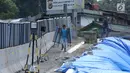 Pekerja melintasi area lokasi longsor di kawasan Ciloto, Cianjur, Jawa Barat, Sabtu (31/3). Area longsor mulai diperbaiki oleh pihak terkait. (Liputan6.com/Helmi Fithriansyah)