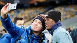 Seorang penggemar berselfie dengan penyerang Chelsea, Callum Hudson-Odoi selama sesi pelatihan di NSC Olympiyskiy, Kiev, Ukraina (13/3). Chelsea akan bertanding melawan Dynamo Kiev pada leg kedua babak 16 besar Liga Europa. (Reuters/Valentyn Ogirenko)