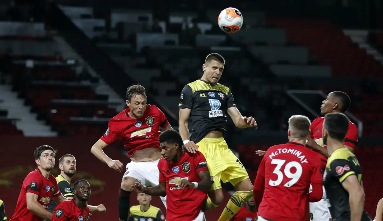 Bek Southampton, Jan Bednarek, berebut bola dengan pemain Manchester United pada laga lanjutan Premier League pekan ke-35 di Stadion Old Trafford, Selasa (14/7/2020) dini hari WIB. Manchester United bermain imbang 2-2 atas Southampton. (AFP/Clive Brunskill/pool)