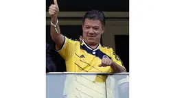Presiden Kolombia, Juan Manuel Santos, memberikan acungan jempol buat kedua tim yang berlaga di babak penyisihan Piala Dunia 2014 Grup C di Stadion National Mane Garrincha, Brasil, (19/6/2014).(AFP PHOTO/Adrian Dennis)
