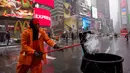 Michael Vante membersihkan salju di New York Times Square, (21/3). Badai salju yang melanda sebagian Amerika Serikat telah membawa salju dan angin kencang. (AP Photo / Mary Altaffer)