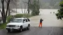 Seorang pria mengambil gambar kawasan yang banjir di sekitar Sungai Rusia di California, AS, Selasa (10/1). Kejadian itu memicu dievakuasinya lebih dari 3.000 orang penduduk dalam semalam di wilayah Guerneville. (AP Photo / Eric Risberg)