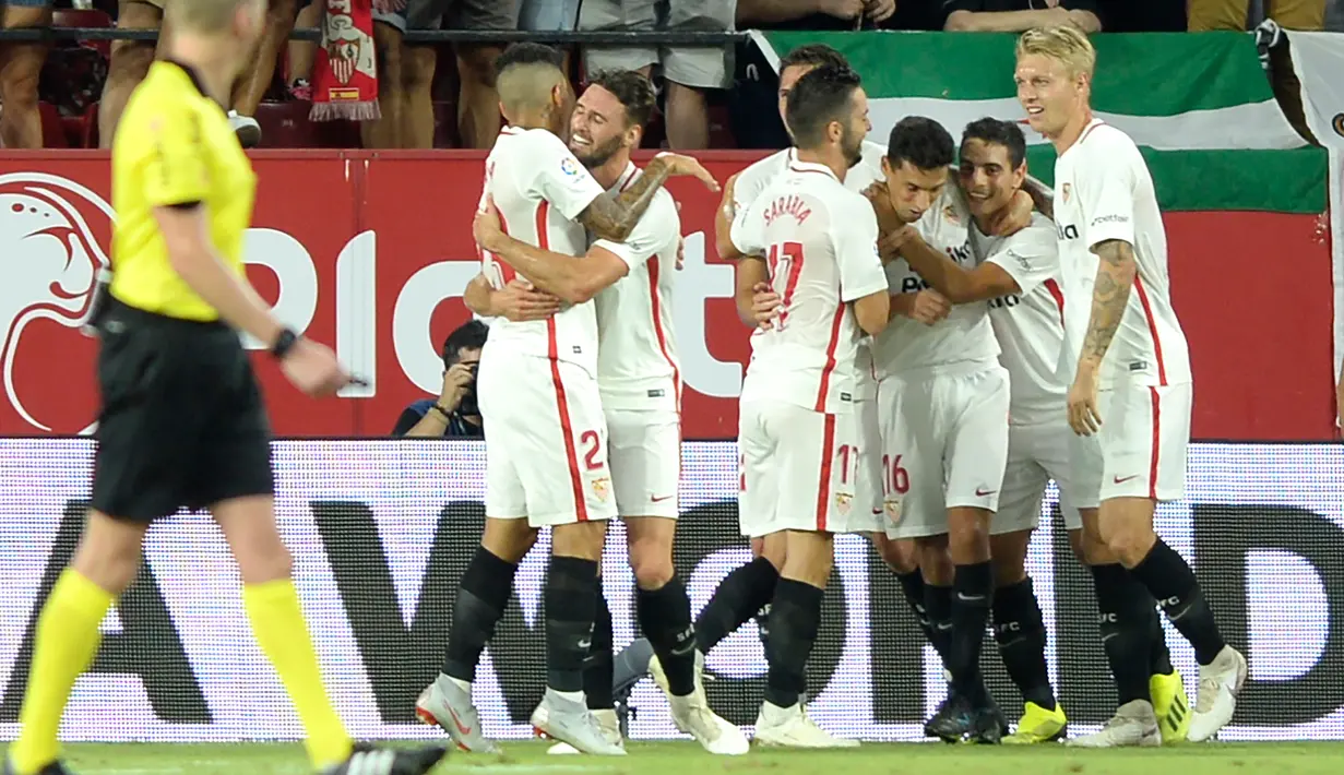 Pemain Sevilla, Wissam Ben Yedder (kedua kanan) berselebrasi usai mencetak gol ke gawang Real Madrid pada lanjutan La Liga Spanyol di stadion Sanchez Pizjuan (26/9). Sevilla menang telak 3-0 atas Madrid. (AFP Photo/Cristina Quicler)