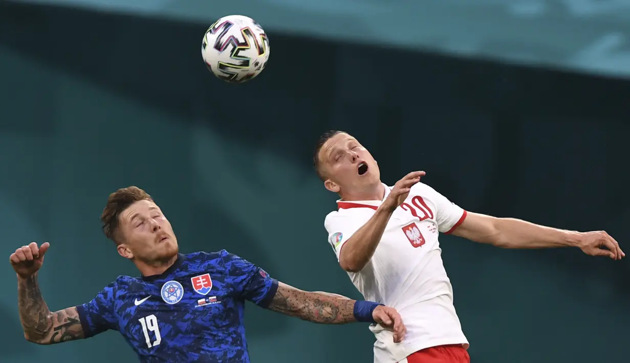 Gelandang Slovakia, Juraj Kucka berebut bola udara dengan pemain Polandia, Piotr Zielinski pada pertandingan grup E Euro 2020 di stadion Saint Petersburg di St. Petersburg, Rusia, Senin (14/6/2021).  Slovakia menang tipis atas Polandia 2-1. (Kirill Kudryavtsev/Pool via AP)