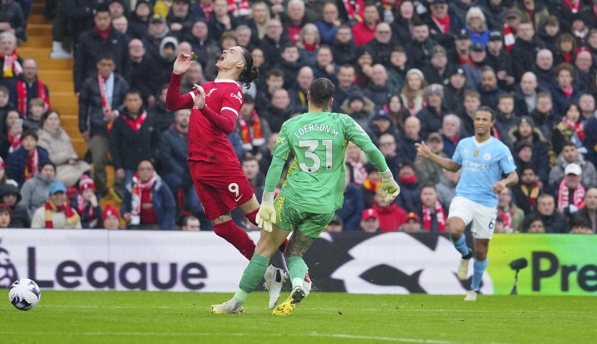 Kiper Manchester City, Ederson menjatuhkan striker Liverpool, Darwin Nunez di dalam kotak penalti yang berujung hukuman tendangan penalti pada laga pekan ke-28 Premier League 2023/2024 di Anfield Stadium, Liverpool, Minggu (10/3/2024). (AP Photo/Jon Super)