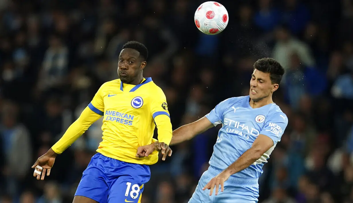 Peain Manchester City Rodrigo (kanan) berebut bola udara dengan pemain Brighton and Hove Albion Danny Welbeck pada pertandingan sepak bola Liga Inggris di Etihad Stadium, Manchester, Inggris, 20 April 2022. Manchester City menang 3-0. (AP Photo/Dave Thompson)