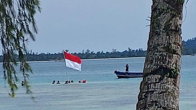 upacara pengibaran bendera merah putih dari bawah laut/Reza Efendi