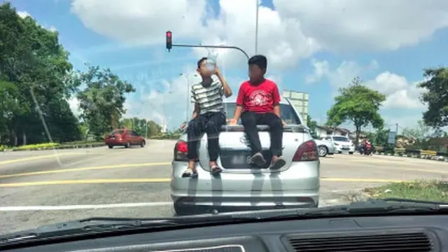 Viral Aksi Bocah Asik Bersantai di Atap Mobil yang Berjalan, Warganet Geram