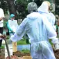 Seorang pria dan anak perempuan menyaksikan pemakaman jenazah korban COVID-19 di TPU Tegal Alur, Jakarta, Kamis (17/12/2020). Hingga hari ini, intensitas pemakamanan korban covid-19 di DKI masih tinggi dengan rata-rata yang dimakamkan mencapai 30 hingga 38 jenazah per hari. (merdeka.com/Arie basuki)
