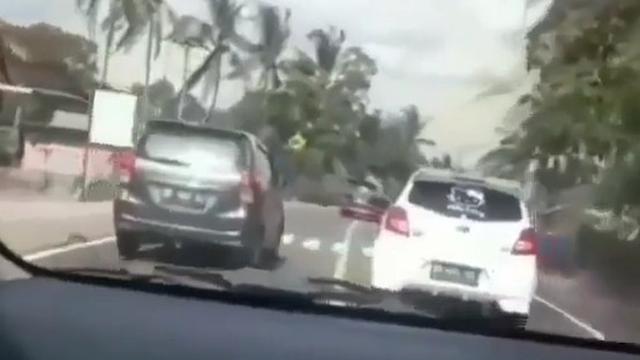 terlihat sebuah mobil berkelir putih mencoba beberapa kali menyalip mobil yang berada di depan dengan kecepatan tinggi.