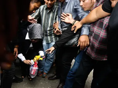 Sylviana Murni memungut sampah usai diperiksa Bareskrim di Gedung Ombudsman, Jakarta, Senin (30/1). Panggilan tersebut terkait pemeriksaan kasus dugaan korupsi pembangunan Masjid Al-Fauz. (Liputan6.com/Faizal Fanani)