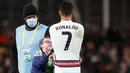 Penyerang Portugal Cristiano Ronaldo memberikan jerseynya untuk fans cilik Irlandia pada akhir laga Grup A Kualifikasi Piala Dunia 2022 Zona Eropa di Stadion Aviva, Jumat (12/11/2021) dinihari WIB. Fans cilik itu nekat menerobos petugas keamanan stadion untuk bertemu Ronaldo. (AP/Peter Morrison)