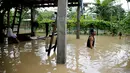 Warga berjalan menyusuri banjir yang menggenangi sebuah desa di Kota Quezon, Metropolitan Manila, Filipina, Jumat (20/7). Banjir menyebabkan siswa sekolah diliburkan selama tiga hari. (AP Photo/Aaron Favila)