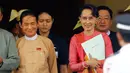 Presiden Myanmar yang baru terpilih Win Myint dan pemimpin Myanmar Aung San Suu Kyi meninggalkan gedung parlemen di Naypyitaw, Rabu (28/3). Sekutu dekat Aung San Suu Kyi ini telah terpilih sebagai presiden baru Myanmar oleh parlemen. (AP/Aung Shine Oo)