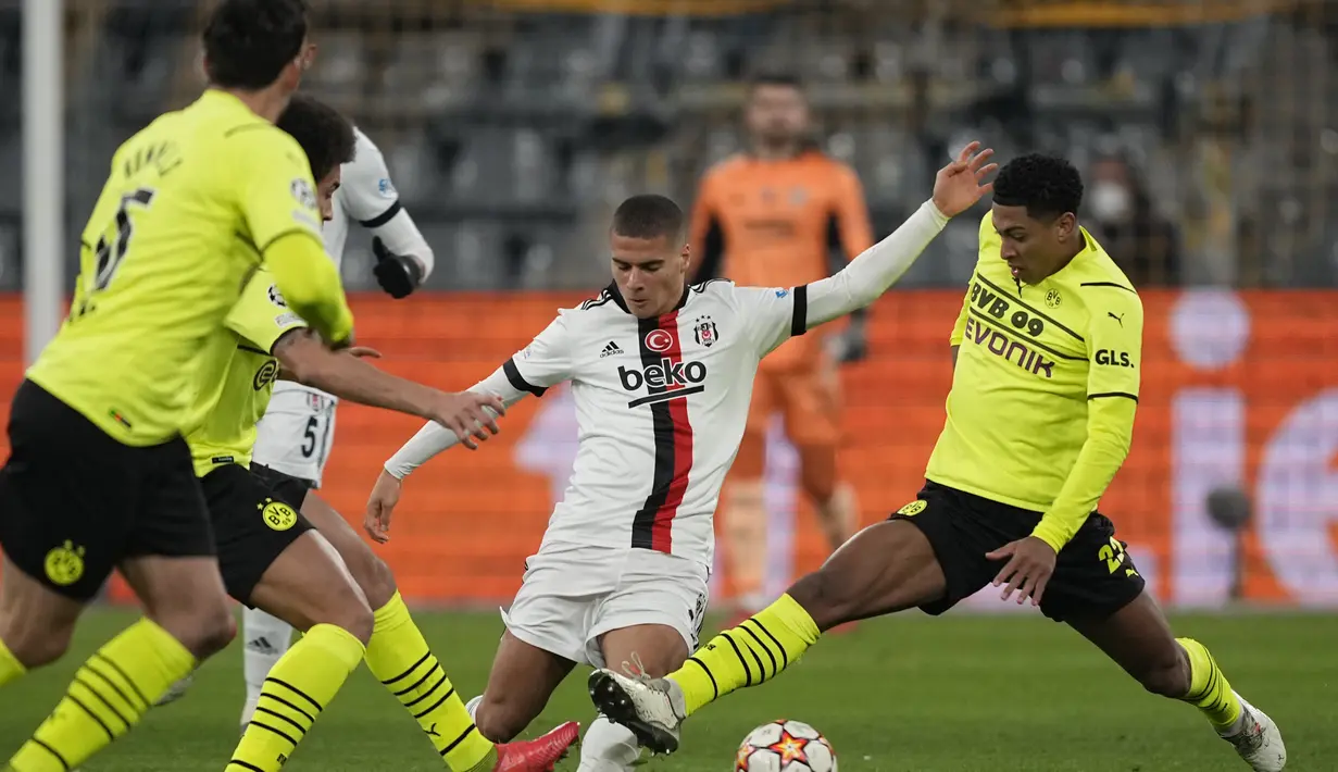 Pemain Besiktas. Can Bozdogan berebut bola dengan pemain Dortmund Jude Bellingham dalam pertandingan Grup C Liga Champions di Signal Iduna Park, Jerman, Rabu (8/12/2021). Dortmund menang telak atas Besiktas dengan skor 5-0. (AP Photo/ Martin Meissner)