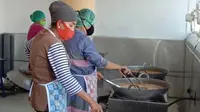 Ibu-ibu yang tergabung dalam Koperasi Wanita Ikatan Ahli Boga (Kopwan IKABOGA) membuat masakan rendang yang dikemas dalam Subana Bana Randang di Kota Padang. (Liputan6.com/HO)