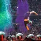 Aksi panggung Chris Martin yang melompat saat tampil di The Stade de France Arena di Saint Denis, Paris, Prancis (15/7). (AFP Photo/Geoffroy Van Der Hasselt)