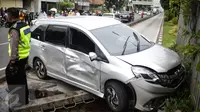 Polisi berjaga didekat mobil yang menabrak separator busway matraman arah kampung melayu, Jakarta, Sabtu (25/2). (Liputan6.com/Faizal Fanani)