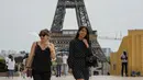 Orang-orang melintasi alun-alun Trocadero dekat Menara Eiffel di Paris, Kamis (17/6/2021). Prancis mengumumkan melonggarkan aturan pembatasan COVID-19, mencabut aturan penggunaan masker di luar ruangan dan menghentikan jam malam mulai pekan ini setelah delapan bulan terakhir. (AP Photo/Michel Euler)