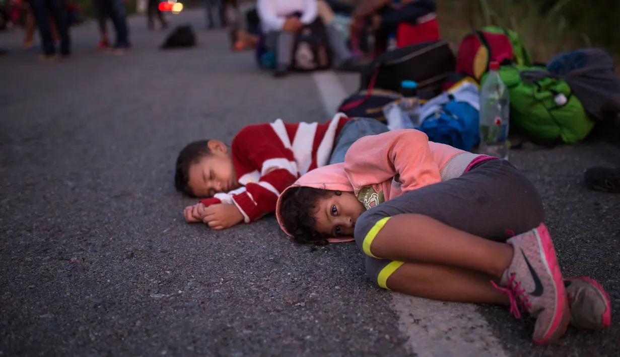 Anak-anak Rombongan imigran Amerika Tengah tujuan Amerika Serikat menunggu tumpangan di sisi jalan saat melangsungkan perjalanan dekat Tapanatepec, Meksiko, Senin (29/10). (AP Photo/Rodrigo Abd)
