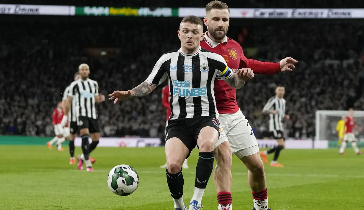 Bek Manchester United (MU) Luke Shaw berebut bola dengan bek Newcastle United Kieran Trippier pada partai final Carabao Cup 2022/2023 di Stadion Wembley, Senin dini hari WIB (27/2/2023). MU tampil tangguh untuk membekuk Newcastle dengan skor meyakinkan 2-0 dan menjadi juara Carabao Cup 2022-2023. (AP Photo/Alastair Grant)