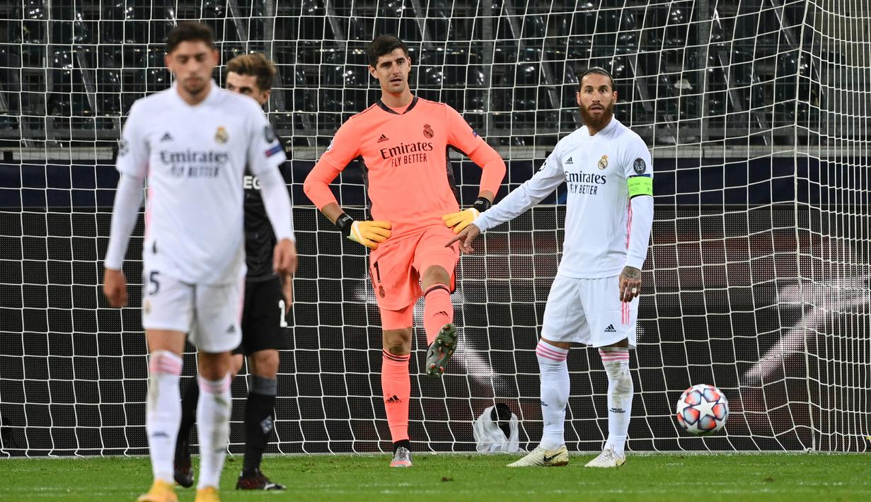 Kiper Real Madrid, Thibaut Courtois, tampak kecewa usai gawangnya kebobolan oleh Borussia Monchengladbach pada laga lanjutan Liga Champions di Borussia Park, Rabu (28/10/2020) dini hari WIB. Real Madrid bermain imbang 2-2 lawan Borussia Monchengladbach. (AFP/Ina Fassbender)
