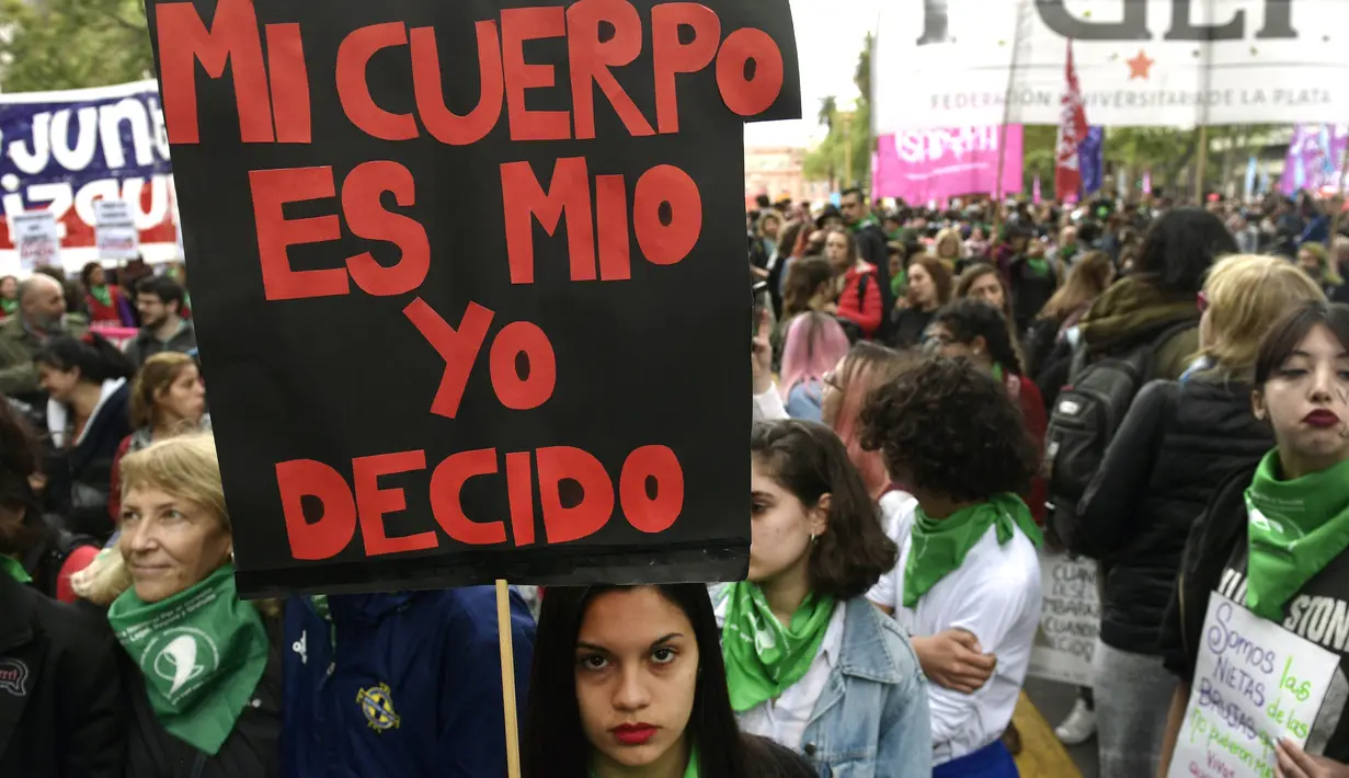 Seorang demonstran menunjukan poster saat menggelar aksi di Buenos Aires, Argentina (29/9). Dalam aksi ini mereka meminta dekriminalisasi aborsi, atau meminta perbuatan aborsi bukan lagi menjadi pelanggaran hukum. (AFP Photo/Juan Mabromata)