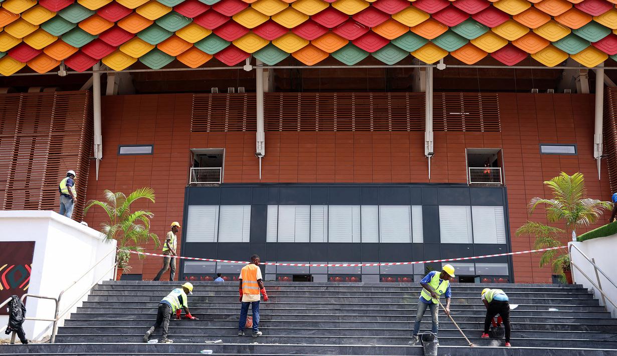 Sejumlah pekerja sedang mempersiapkan fasilitas Stadion Olembe yang terletak di Yaounde, pada 7 Januari 2022. Stadion yang berkapasitas 60.000 penonton tersebut rencananya akan digunakan untuk venue pembukaan Piala Africa 2021. (AFP/Kenzo Tribouillard).