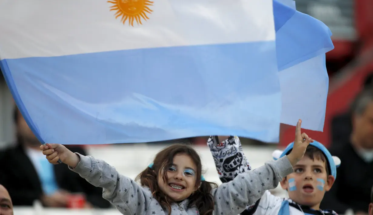 Seorang anak membentangkan bendera Argentina pada laga Pra-Piala Dunia 2018 zona CONMEBOL di Stadion Monumental Antonio Verspucio Liberti,Buenos Aires, Argentina, Sabtu (14/11/2015) WIB. Argentina dan Brasil bermain imbang 1-1. (REUTERS/Martin Acosta)