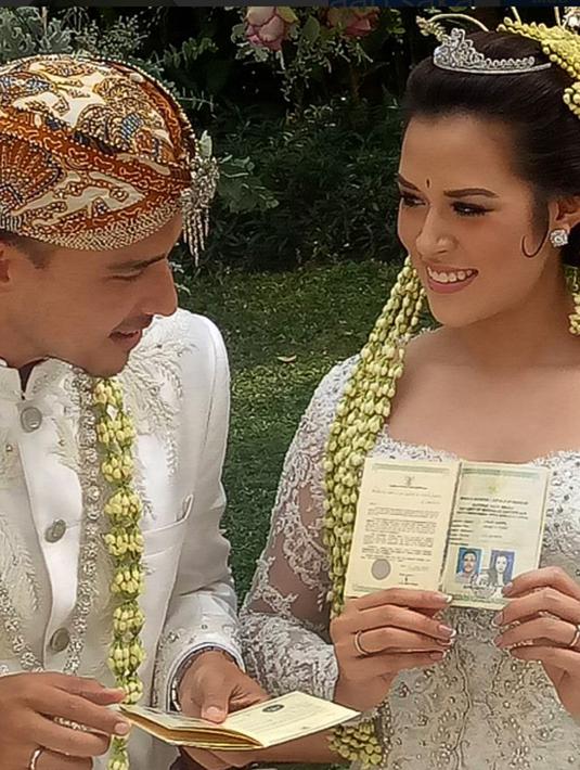 Penyanyi Raisa dan Hamish Daud menunjukkan buku pernikahan usai melangsungkan akad nikah. (Instagram@aan.saka)