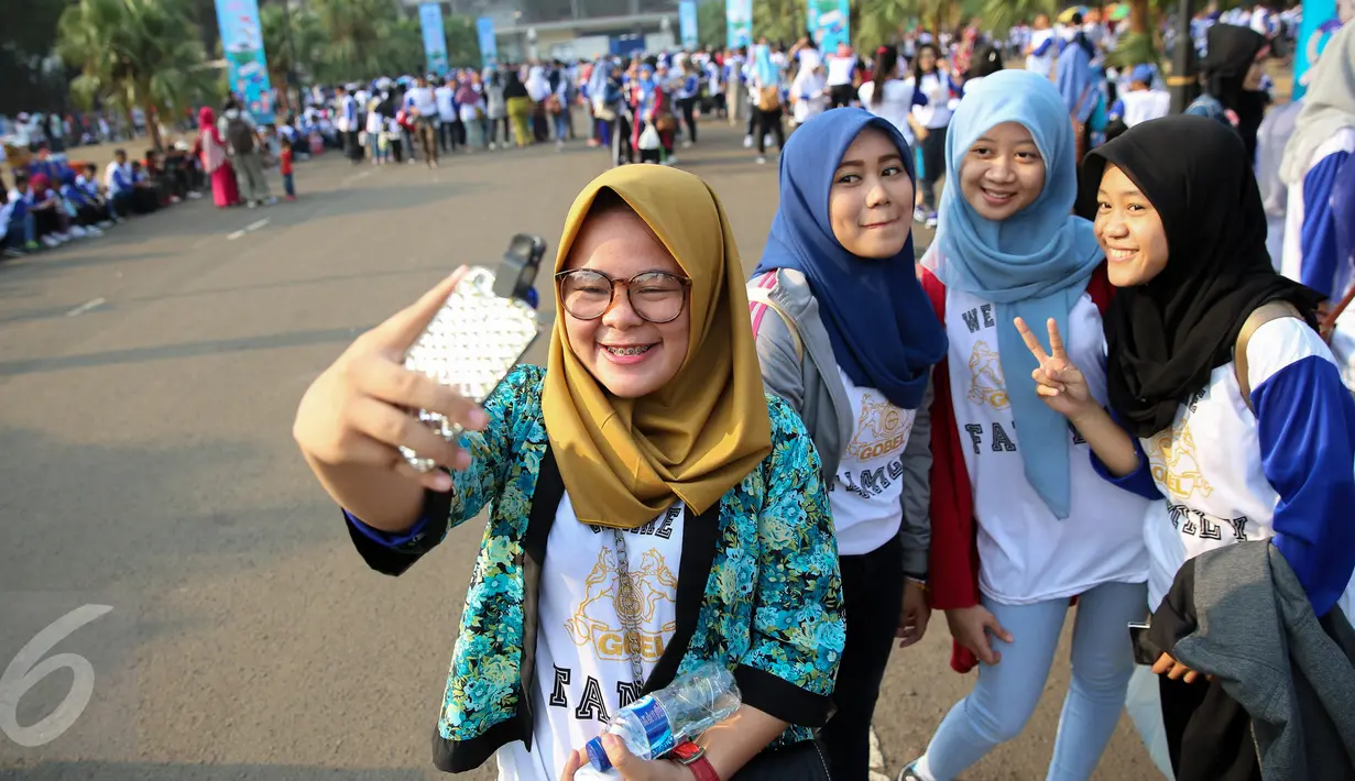 Sejumlah karyawan berselfie saat rangka family gathering karyawan PT. Panasonic Gobel Indonesia, Jakarta, Minggu (11/10/2015). Acara ini diawali dengan jalan sehat, yang dipimpin oleh bos Panasonic Rachmat Gobel. (Liputan6.com/Faizal Fanani)