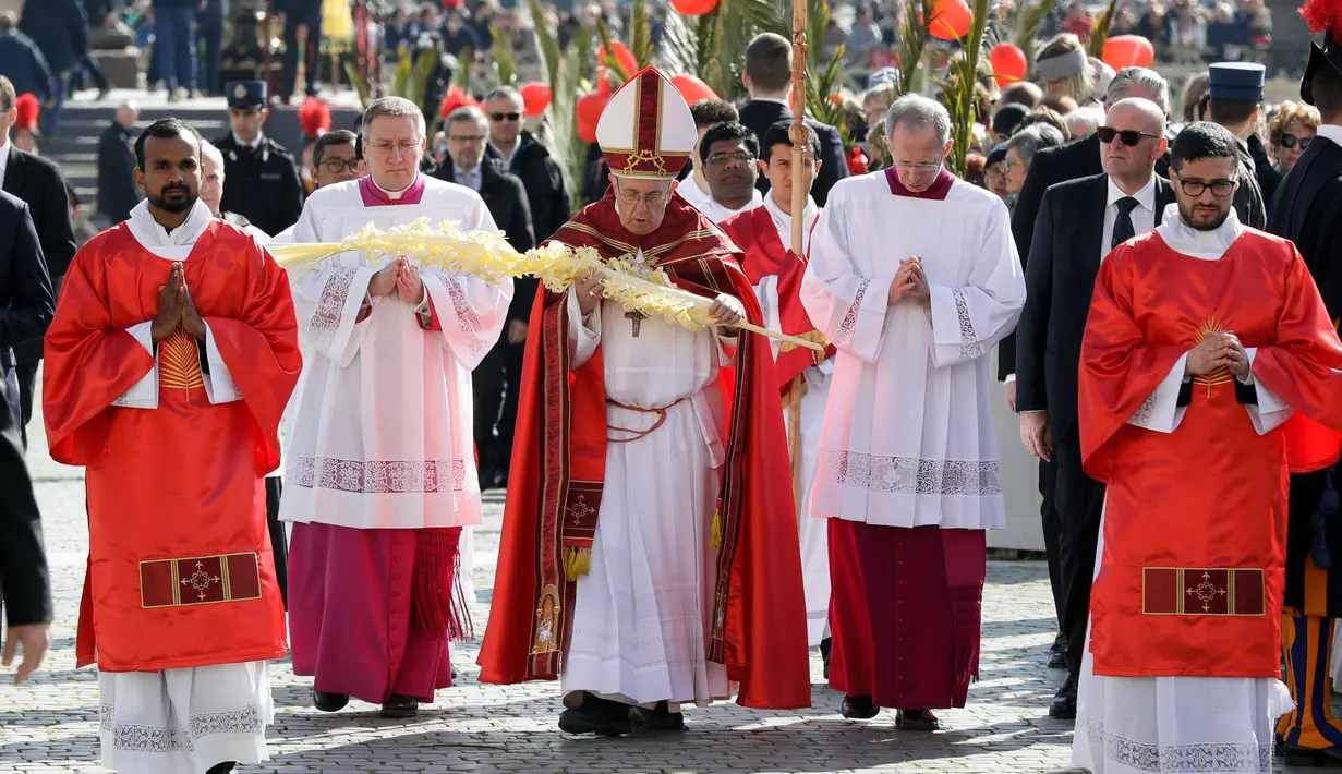 Paus Fransiskus memegang daun palem saat merayakan Misa Minggu Palma di Lapangan Santo Petrus di Vatikan (25/3). (AP Photo / Andrew Medichini)